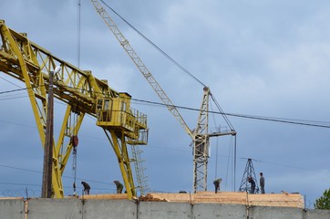 A gantry crane and simple crane with workers