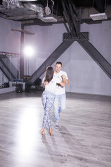 Young man and woman having fun while dancing with her partner