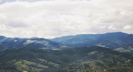 Mountain valley village landscape. Cloudy sky