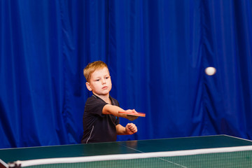 child playing table tennis in the gym
