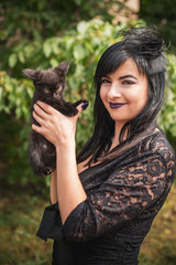 Halloween party concept, mysterious girl with black cat. Beautiful young dark witch woman. Inspiration for halloween celebration, ideas and simple nice detail   