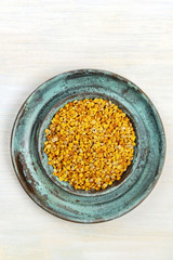 An overhead photo of pollen, shot from above on a light background with copy space