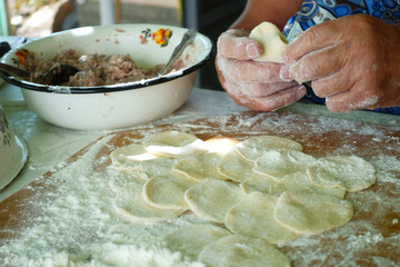 Fototapeta premium Home-made recipe for dumplings (raviol)i. Traditionally, women of the older generation mold the dumplings in the family.