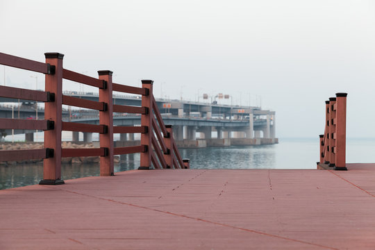 Empty red wooden pier in foggy evening