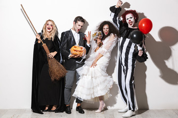 Group of cheerful friends dressed in scary costumes