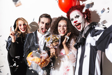 Group of happy friends dressed in scary costumes