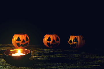 Candles and Halloween pumpkins are placed on wooden floors.