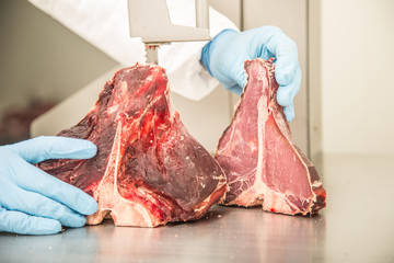 worker on band saw cut meat in a meat shop