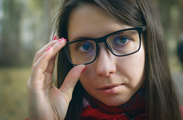 Face portrait of young caucasian woman with long brown hair in eyeglasses and stoles.