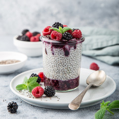 chia seeds pudding with berry sauce and fresh raspberry and blackberry in glass