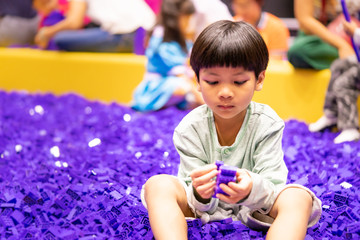 boy is playing with purple educational toy block