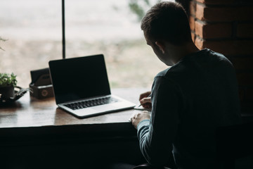 Student working and drinking coffee in a cafe and write down something in the notebook. Prepare for an exam
