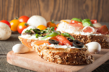 Italian tomato and cheese bruschetta. Tapas, antipasti with chopped vegetables, herbs and oil on grilled ciabatta and baguette bread.