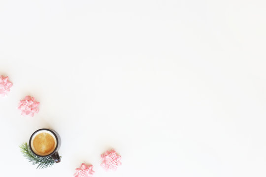 Four white-and-red bows for decorating Christmas gifts on a white background next to a cup of coffee with froth. Minimalism. Top view, flat lay, copy space