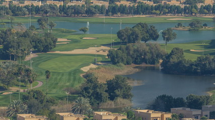Beautiful golf course near modern skyscrapers of Dubai Marina timelapse in luxury Dubai city, United Arab Emirates