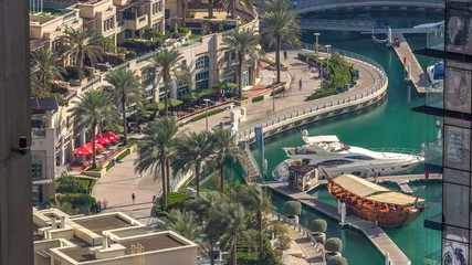 Fototapeta premium Promenade and canal in Dubai Marina timelapse with boats around, United Arab Emirates