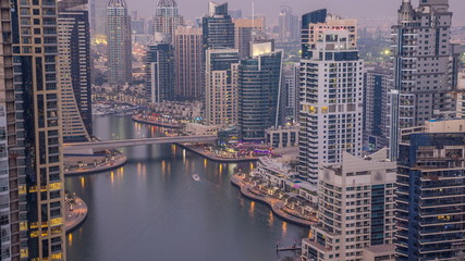 Fototapeta na wymiar Beautiful aerial top view day to night transition timelapse of Dubai Marina canal
