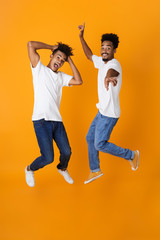 Fototapeta na wymiar Full length of two happy male african friends in t-shirts