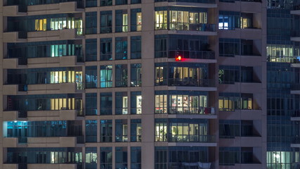 Glowing windows of skyscrapers at evening timelapse