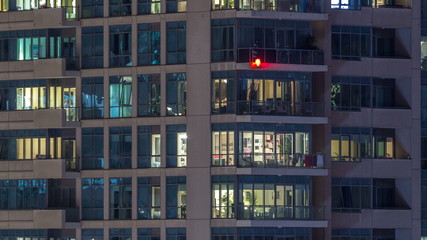 Fototapeta na wymiar Glowing windows of skyscrapers at evening timelapse