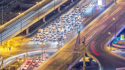 Night traffic on a busy intersection at Dubai downtown highway aerial timelapse