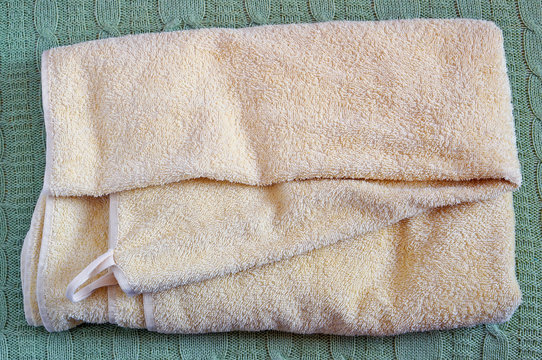 Terry Yellow Bath Towel Lie On A Wool Knitted Bed Coverlet