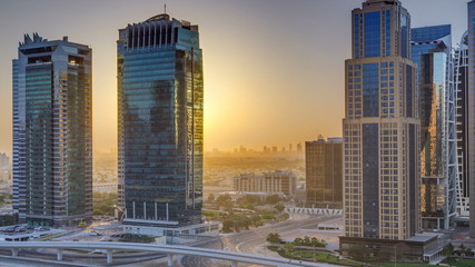 Fototapeta na wymiar Aerial view of Jumeirah lakes towers skyscrapers at sunrise timelapse with traffic on sheikh zayed road.