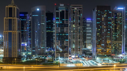 Fototapeta na wymiar Aerial view of Jumeirah lakes towers skyscrapers during all night timelapse with traffic on sheikh zayed road.