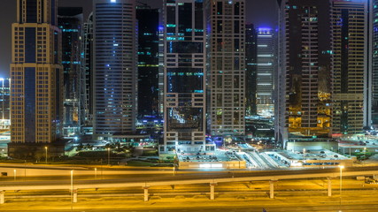 Aerial view of Jumeirah lakes towers skyscrapers during all night timelapse with traffic on sheikh zayed road.