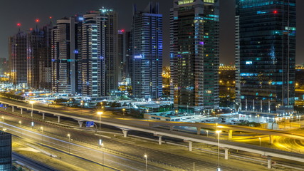 Fototapeta na wymiar Aerial view of Jumeirah lakes towers skyscrapers during all night timelapse with traffic on sheikh zayed road.