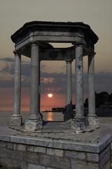 Arbor with Doric columns at sunset by the sea