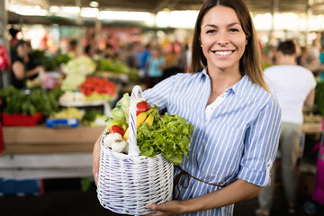 Young woman buying vegetables at the market.