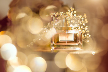 Perfume bottle on golden bokeh background. Aromatic Eau de Toilette
