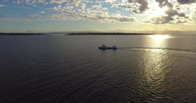 Ship sailing at sunset. Islands in the background