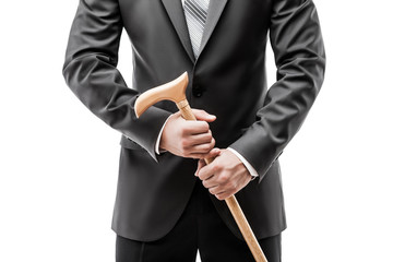 Businessman in black suit holding walking cane stick