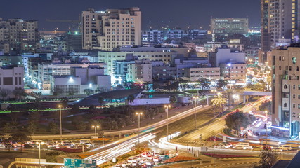 Fototapeta na wymiar Dubai Creek area surrounded by modern buildings and busy traffic street night timelapse