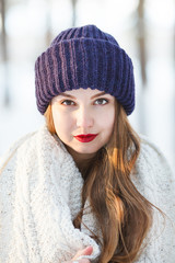 Beautiful woman wearing big knitted blue hat and scarf