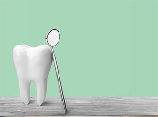 Big tooth and dentist mirror, medical concept
