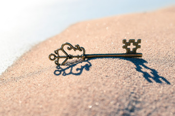 Schlüssel im Sand mit Kreuz Symbol für Glaube als Schlüssel