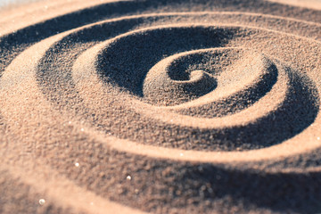 Fototapeta na wymiar Textur Spirale Muster im Sand mit Licht und Schatten Kontrast