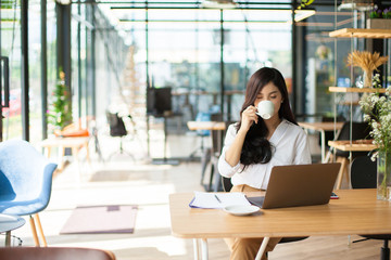 Portrait of Asian pretty young business woman sitting on workplace