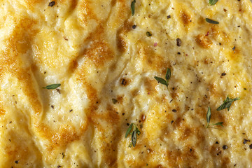 Scrambled eggs or omelette made from eggs and cheese with herbs on the plate