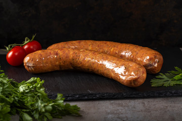 Two smoked pork sausages with herbs and sherry tomatoes