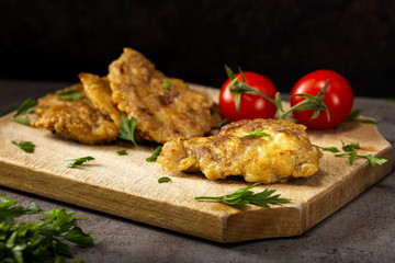 Schnitzel made from pork brain, flour and eggs on a wooden cutting board
