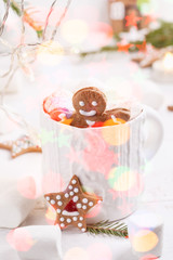Cup of traditional hot chocolate with marshmallows and gingerbread on white table.  Christmas drink in New Year decorations.