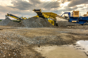 Mobile machinery to transform stone into gravel in the construction works of the road between...