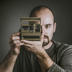 man with vintage instant camera