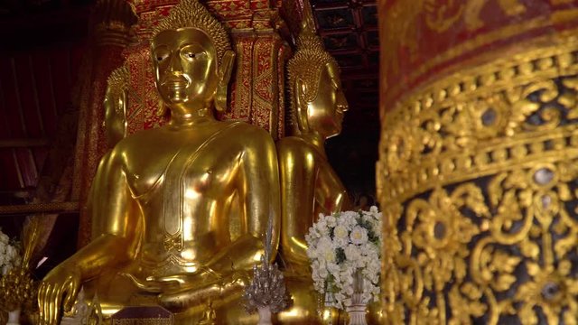 Ancient large gilded Buddhas seated on a raised platform inside Wat Phumin Temple.The most attractive temple in the town of Nan province at Thailand