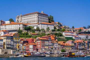 Porto or Oporto, Portugal. Ribeira District with typical colorful buildings, the Douro River and cruise ships for tourists in of Rabelo boats shape - obrazy, fototapety, plakaty