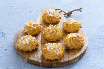 Almond pastry on chopping board on blue background